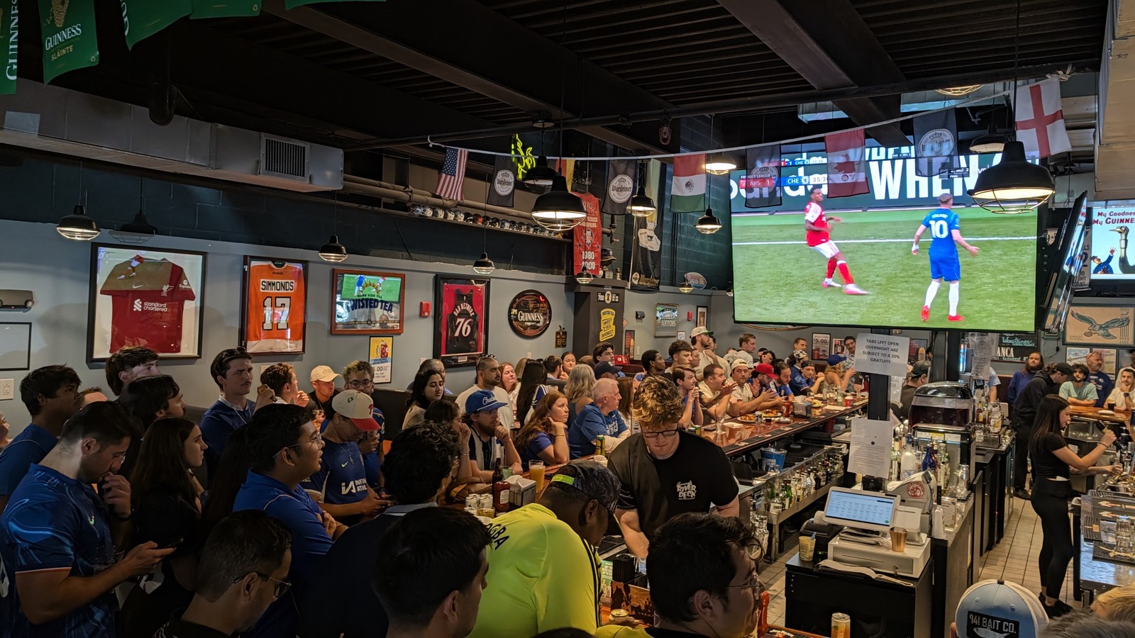 The room at Cavanaugh's Rittenhouse full of supporters in blue Chelsea shirts, framed Philadelphia jerseys along the wall and the Arsenal match playing on the big screen above the bar.